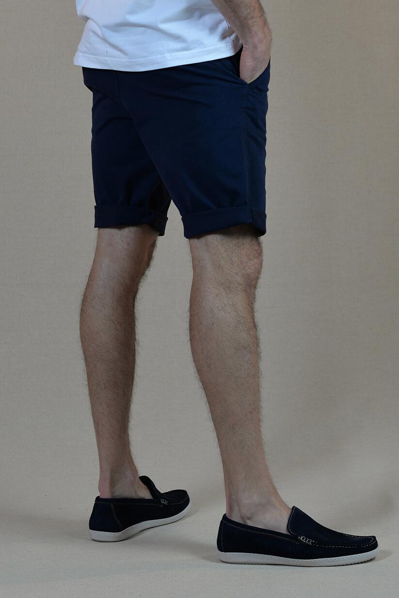 Homme de dos portant un short/bermudas bleu marine brode d'un homard rouge.