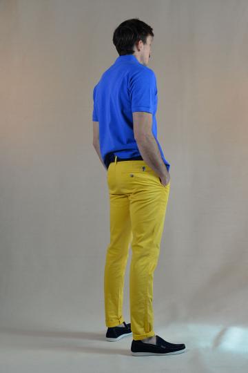 Homme de dos portant un polo bleu avec petit homard orange et un chino jaune.