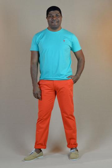 Homme de face portant un tshirt turquoise avec petit homard orange et un chino orange.